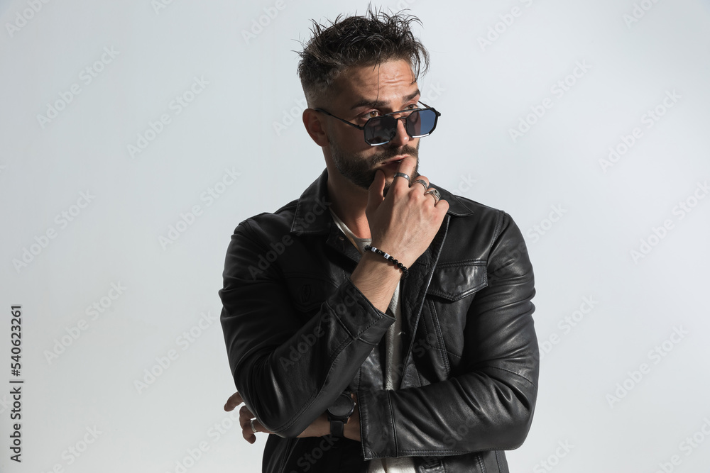 fashion man with messy hair wearing sunglasses and looking away fashion man with messy hair wearing sunglasses and looking away