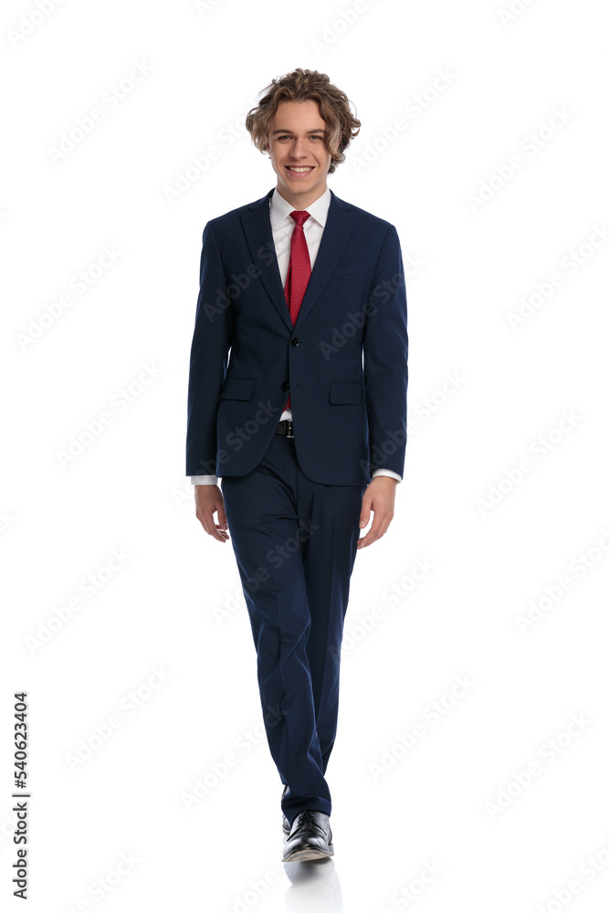 attractive young businessman wearing navy blue suit and walking attractive young businessman wearing navy blue suit and walking