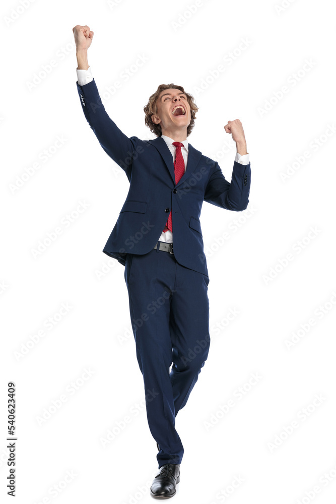 excited young man wearing suit holding fists in the air and cheering excited young man wearing suit holding fists in the air and cheering