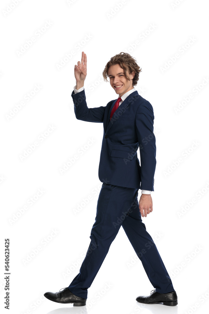 man with curly long hair pointing fingers in the air and saluting