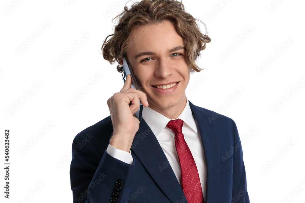 blond man with curly long hair talking on the phone and smiling blond man with curly long hair talking on the phone and smiling