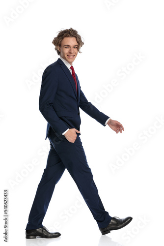 full body picture of happy businessman walking with hand in pocket © Viorel Sima