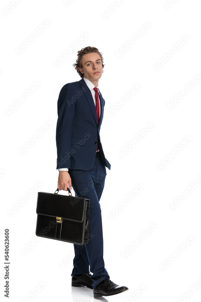 confident cool businessman in suit holding suitcase and walking confident cool businessman in suit holding suitcase and walking