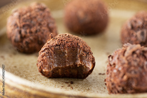 Candy truffles brigadeiro with chocolate on a plate close-up, traditional brazilian sweets.