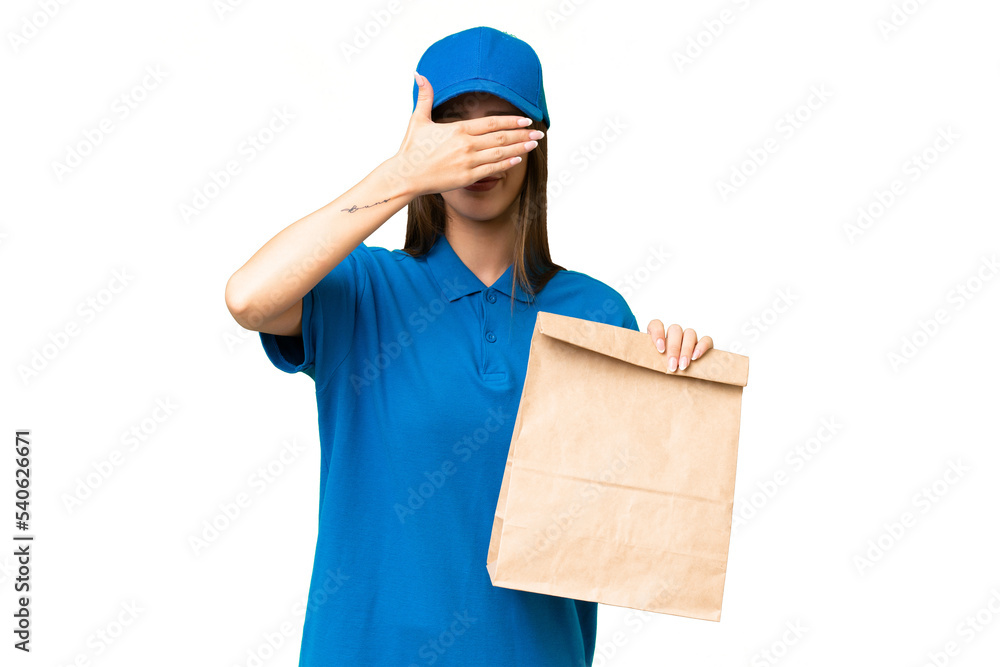 Young beautiful caucasian woman taking a bag of takeaway food over isolated background covering eyes by hands. Do not want to see something