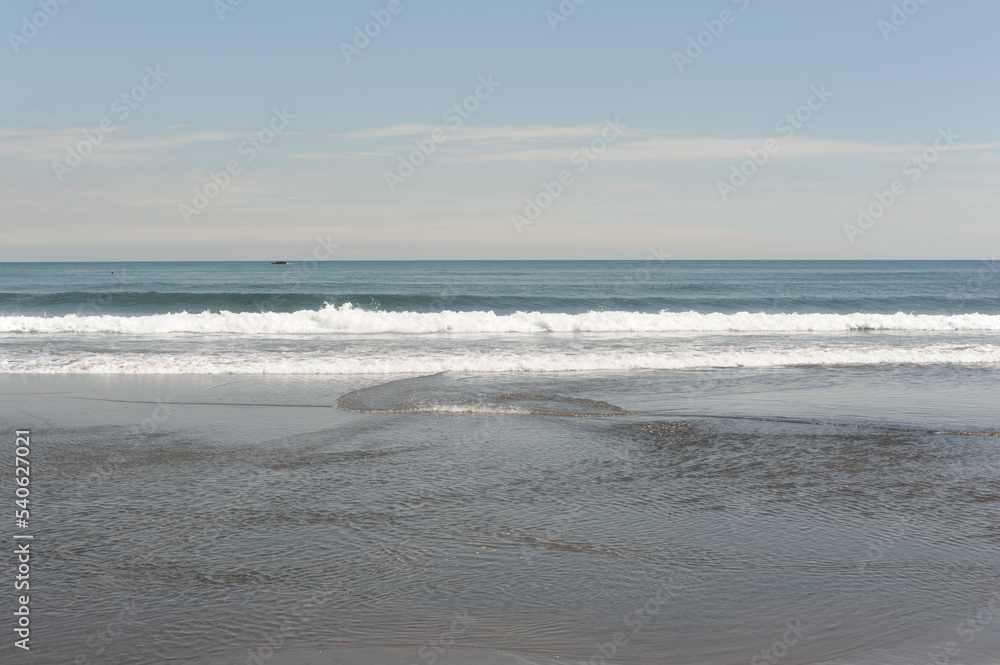 Picturesque seashore with beach and ocean waves and horizon on a sunny day with clear blue sky and calm ocean in Hokkaido, northern Japan, Asia