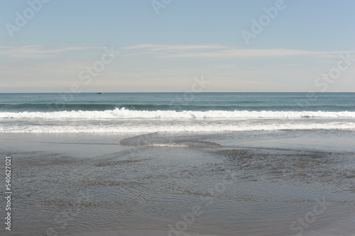 Picturesque seashore with beach and ocean waves and horizon on a sunny day with clear blue sky and calm ocean in Hokkaido, northern Japan, Asia