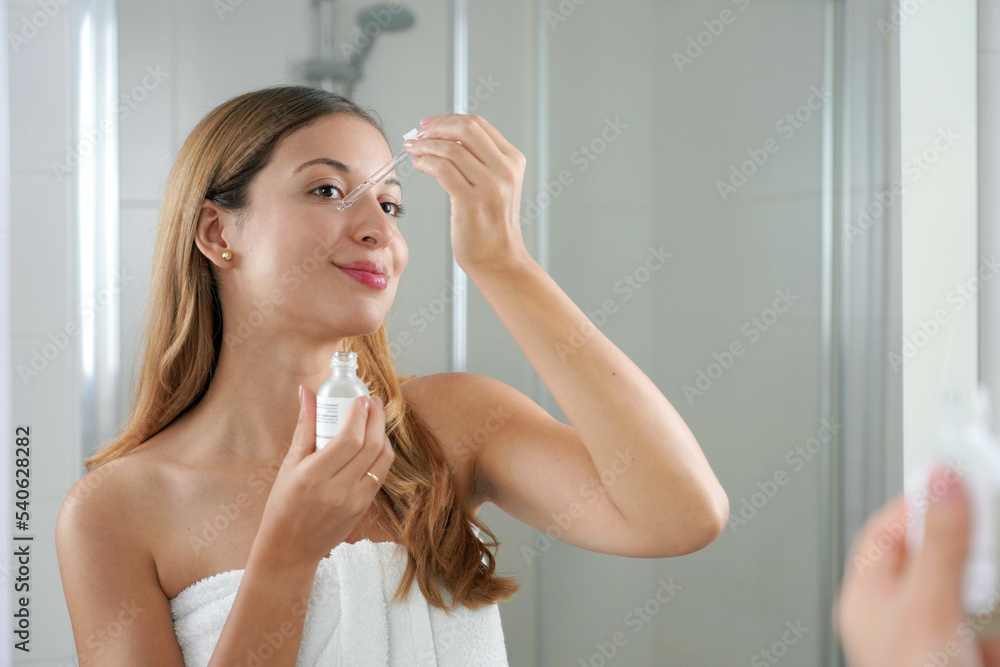 Beauty woman applying hyaluronic acid on the face in the bathroom. Skin care routine. Beauty woman applying hyaluronic acid on the face in the bathroom. Skin care routine.