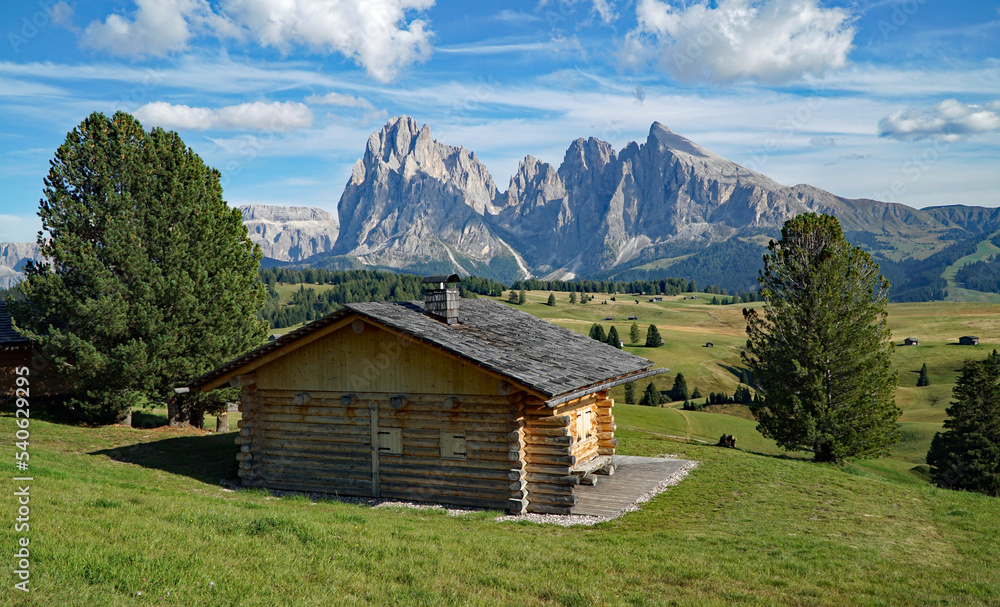 Picturesque wooden cabins on alp in the dolomites. amazing view into gardena valley and to distinctive sassolungo group. picturesue landscape in south tyrol, italy, garda valley. puezodles nature park