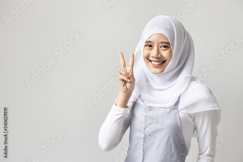 Confident happy smiling muslim woman catering business owner pointing 2 finger, v for victory hand gesture