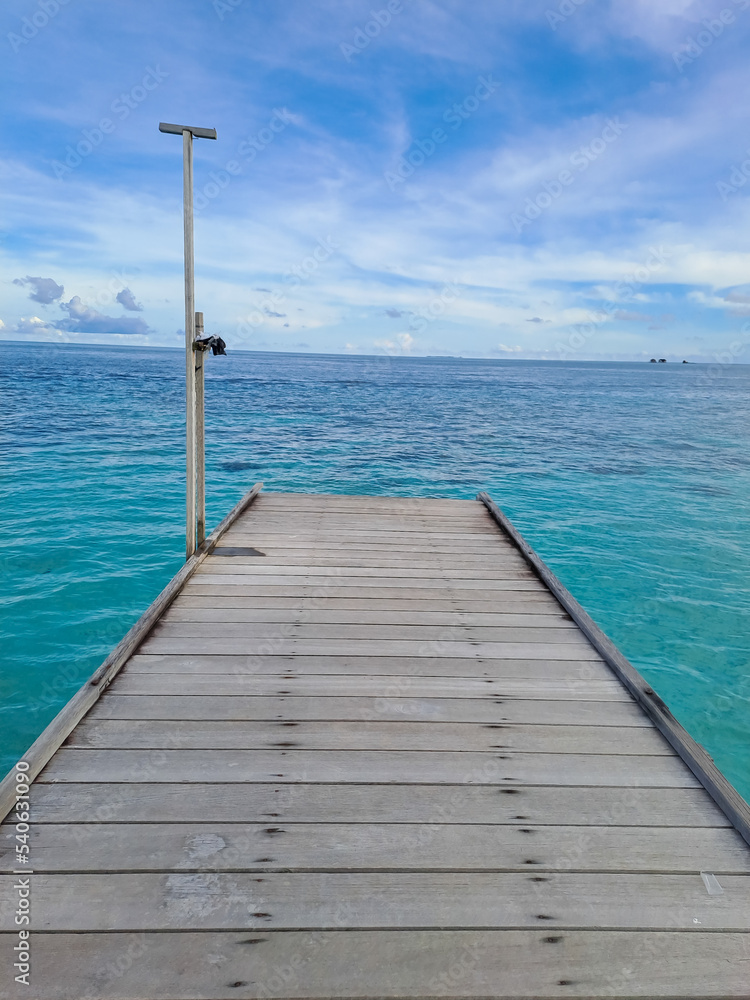 Wooden walkway on the beach. Jetty into the Blue. Derawan Island