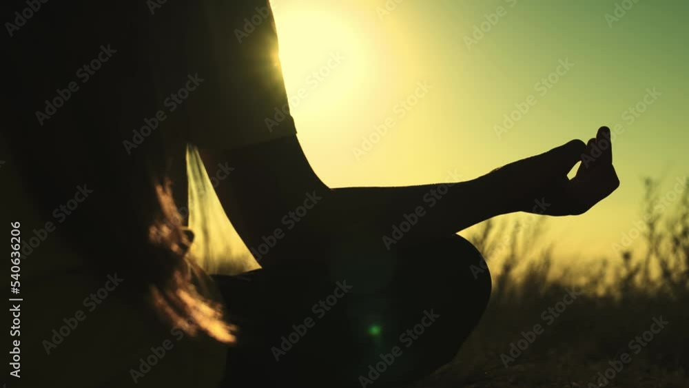 yoga hand sign. girl sunset doing yoga. female meditation glare sun