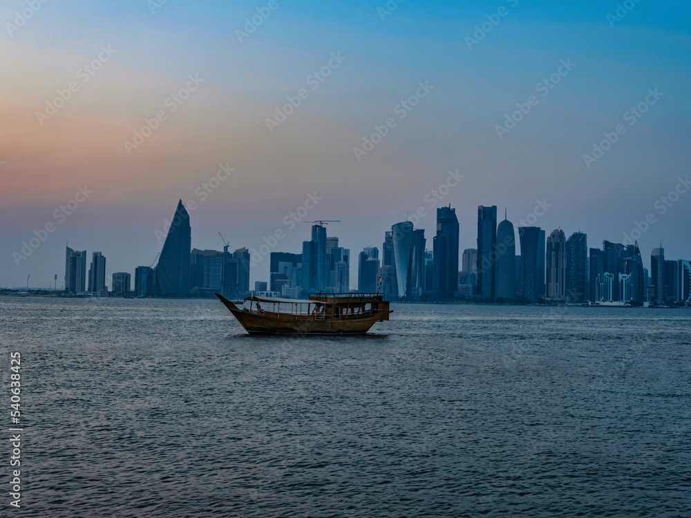 Dhow boat and Doha city skyline during sunset, Doha, Qatar