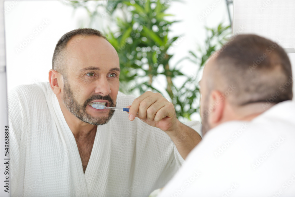 Fototapeta premium a man is brushing teeth
