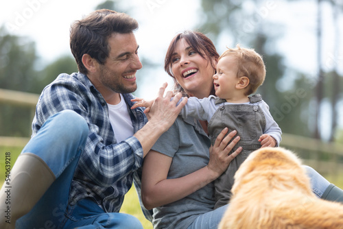 happy family outdoors with their child and dog