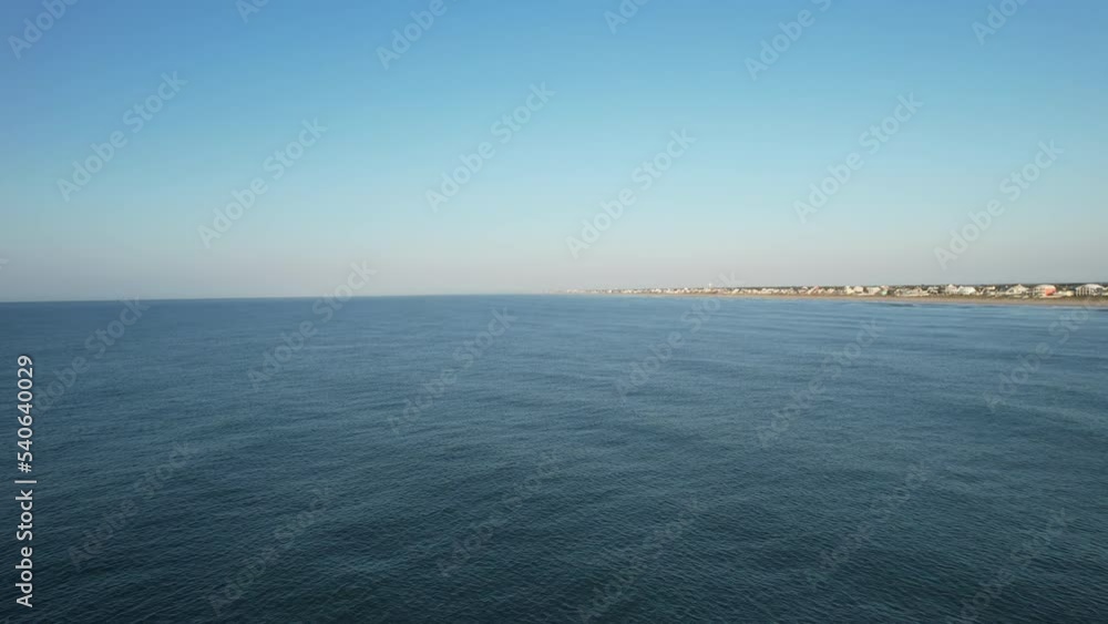 Drone shot flying over ocean with Emerald Isle Beach in the distance in North Carolina Drone shot flying over ocean with Emerald Isle Beach in the distance in North Carolina