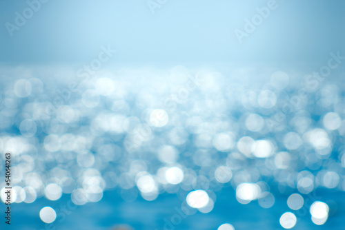 Delicate blue texture bokeh sea. Summer background. Blurry blue bokeh glare on the water on a sunny day. Concept travel. © sergofan2015