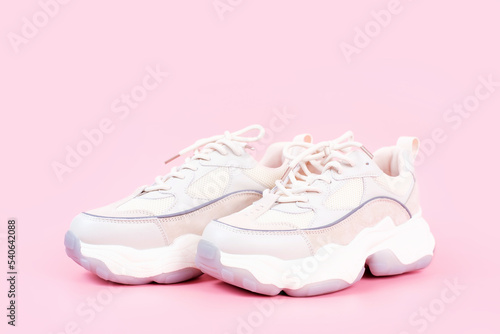 Pair of stylish sneakers on pink background close-up side view.