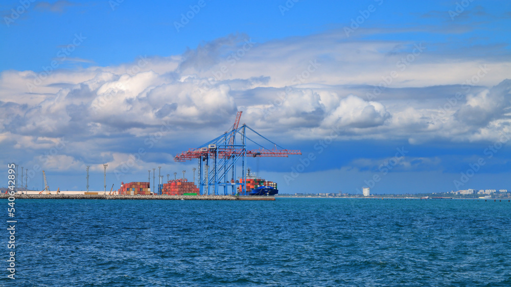 Cloudy sky over sea port cranes.