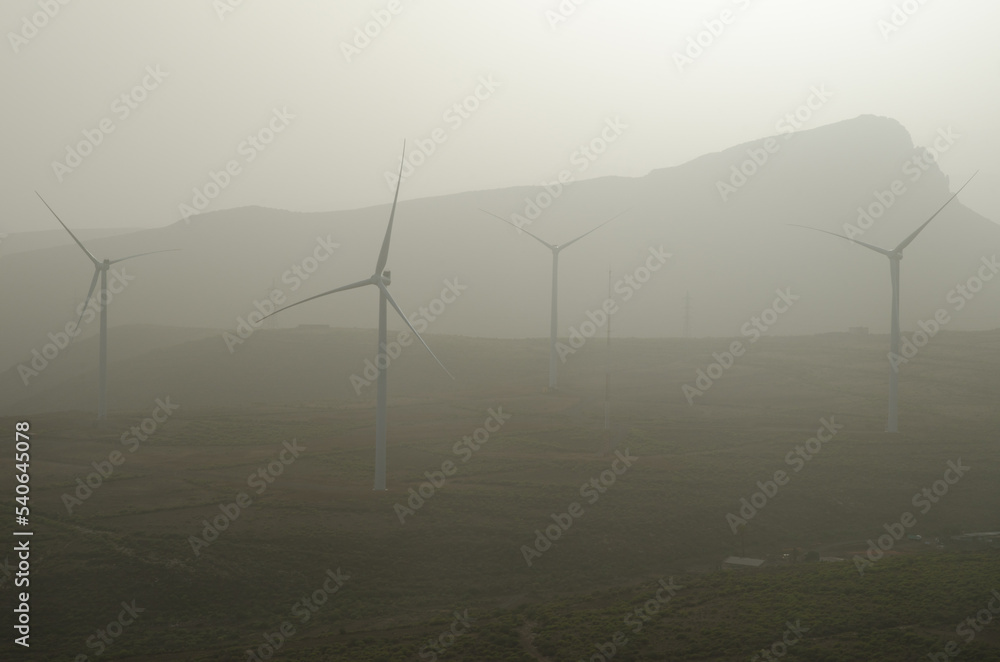 Wind turbines in a day with airborne dust. Aguimes. Gran Canaria. Canary Islands. Spain. Wind turbines in a day with airborne dust. Aguimes. Gran Canaria. Canary Islands. Spain.