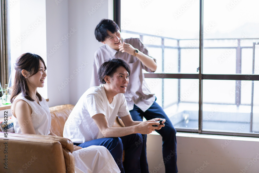 Fototapeta premium 家でテレビゲームをする若い男女