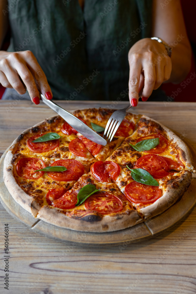 close-up shot of woman eating delicious pizza with cutlery close-up shot of woman eating delicious pizza with cutlery