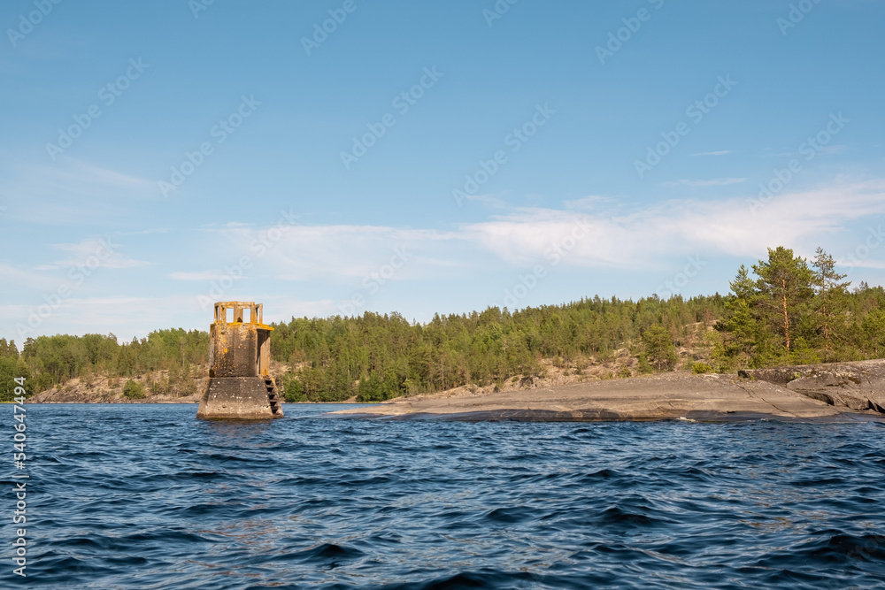 Karelia. Rocky shore with an abandoned lighthouse. Rusty building. Ladoga lake. Skerries