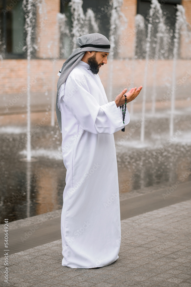 Young bearded arabian man in traditional clothing praying Young bearded arabian man in traditional clothing praying