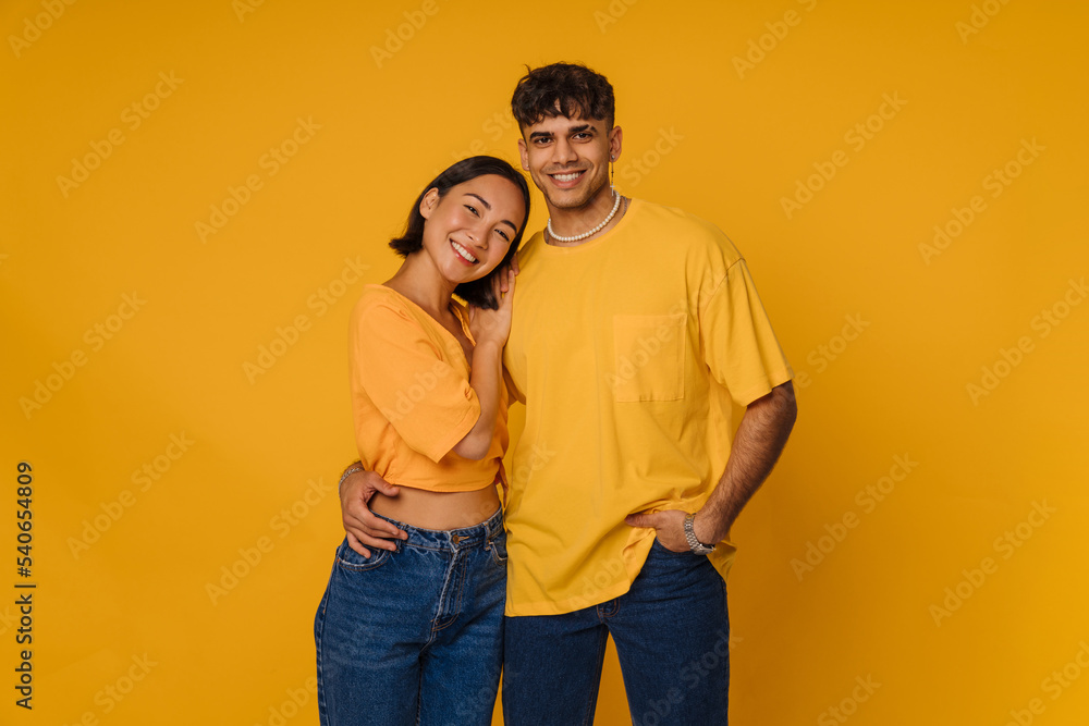 Young multiracial couple hugging while smiling together Young multiracial couple hugging while smiling together