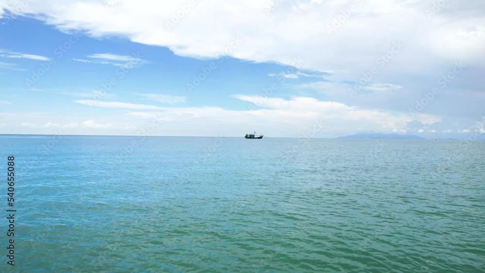 Fishing Boat Anchored And Floating In The Ocean In The Daytime. - low aerial forward shot over water surface Fishing Boat Anchored And Floating In The Ocean In The Daytime. - low aerial forward shot over water surface