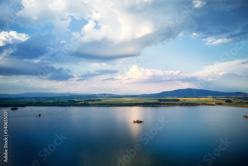 Aerial top view of beautiful landscape with large lake against mountains shapes at summer day. Mietkow lake near Wroclaw  Poland