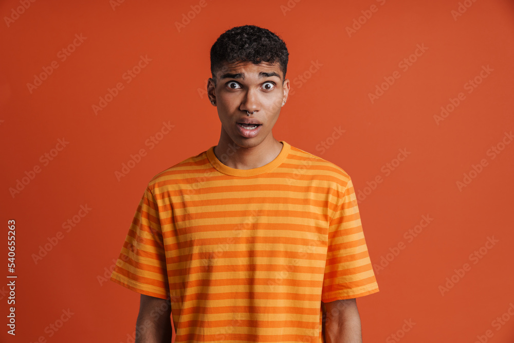Young black man with piercing expressing surprise at camera Young black man with piercing expressing surprise at camera