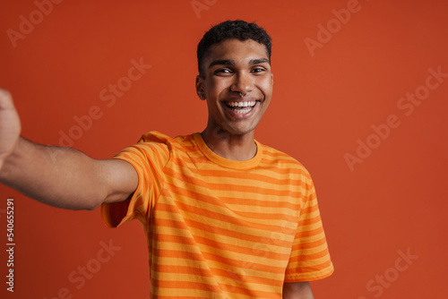 Selfportrait of young handsome smiling happy african man in t-shirt