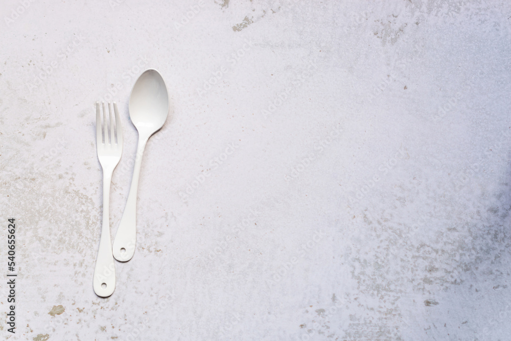 white cutlery set, a pair of fork and spoon on marble background white cutlery set, a pair of fork and spoon on marble background