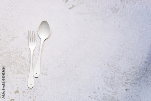 white cutlery set, a pair of fork and spoon on marble background