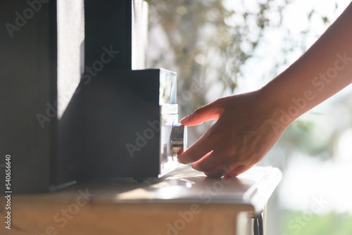 Fototapet Woman hand turns on and listening to music via the Hi-Fi stereo in her home