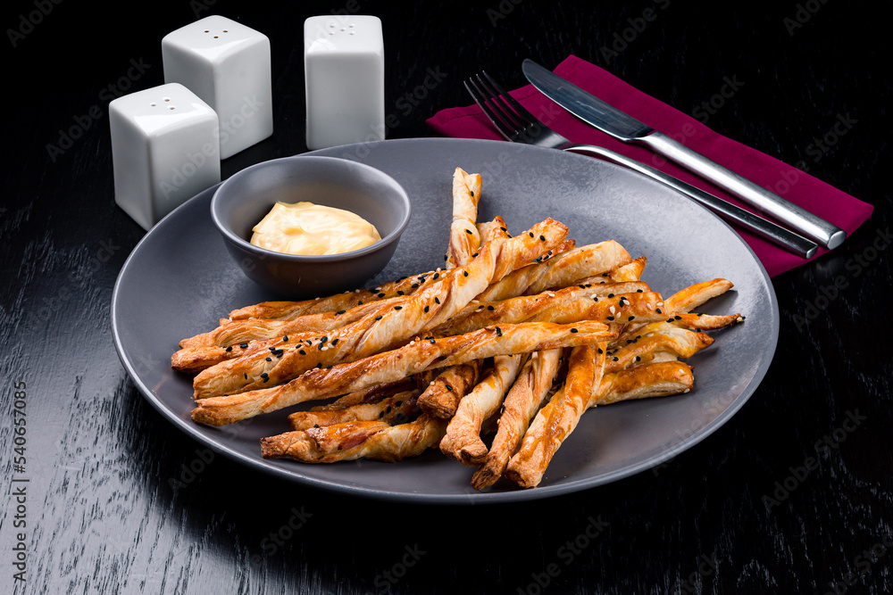 Breadsticks with cheese delicious snack. Grissini with cheese on a gray plate Breadsticks with cheese delicious snack. Grissini with cheese on a gray plate