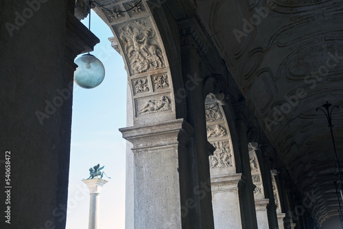 View on the Colonne di San Marco from the gallery of Biblioteca Marciana throw the columns on the St Mark's square in Venice, Italy. With bright blue sky on the background