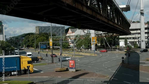 A large intersection in the center of town with a suspended road. Automobile and monorail traffic. Time lapse. photo