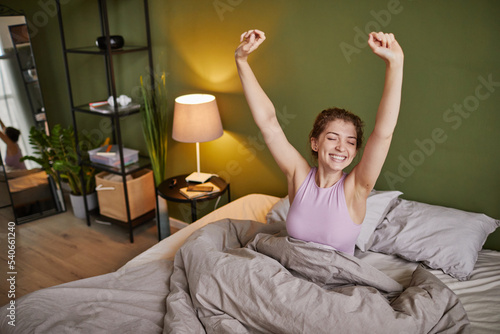 Wallpaper Mural Young girl stretching her arms and smiling while waking up in the morning in bed at home Torontodigital.ca