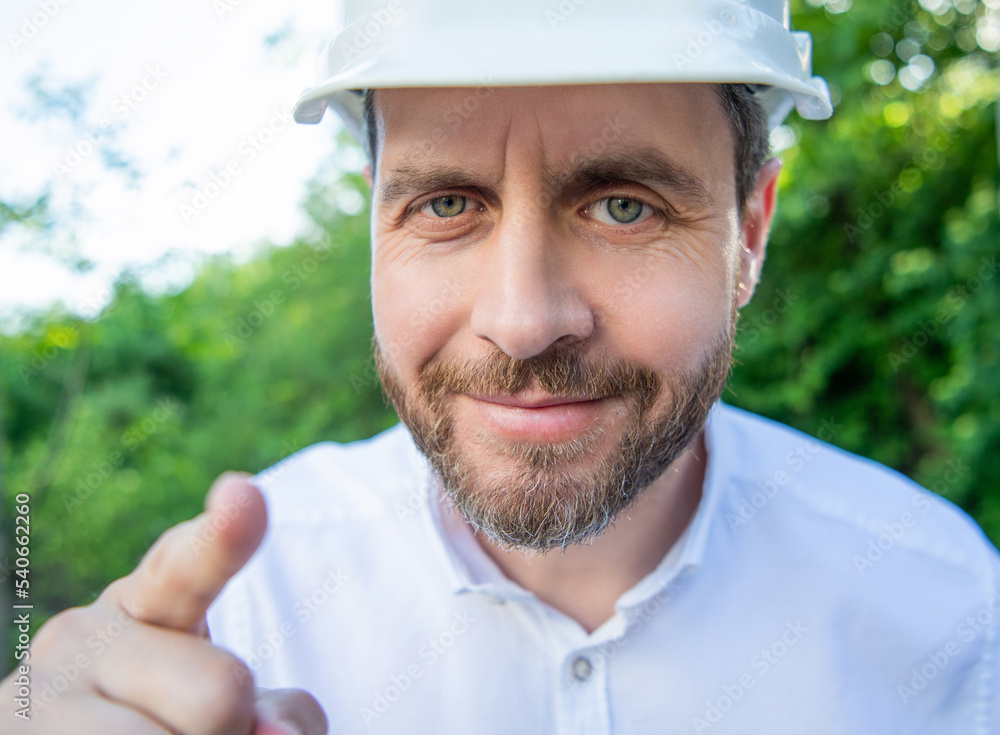 Portrait of worker man in hardhat pointing finger outdoors Portrait of worker man in hardhat pointing finger outdoors