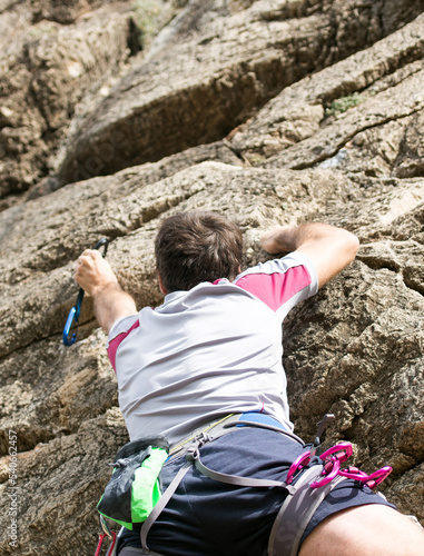 person climbing up the rock