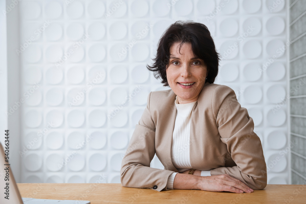middle aged woman connecting to the Internet from home. Smiling businesswoman using a laptop in office middle aged woman connecting to the Internet from home. Smiling businesswoman using a laptop in office