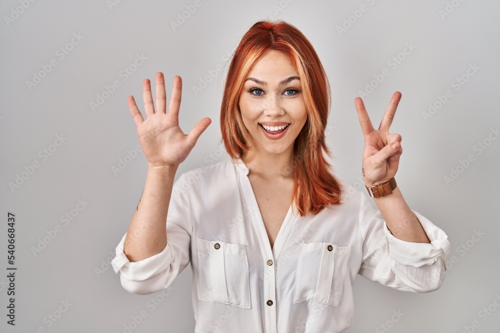 Young caucasian woman standing over isolated background showing and pointing up with fingers number seven while smiling confident and happy. Young caucasian woman standing over isolated background showing and pointing up with fingers number seven while smiling confident and happy.