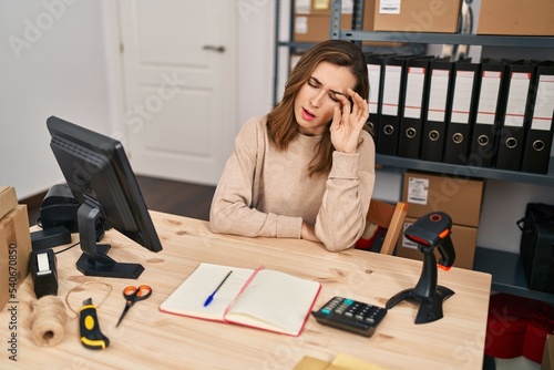 Young woman ecommerce business worker suffering for headache at office