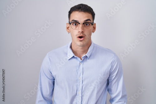 Handsome hispanic man wearing business clothes and glasses afraid and shocked with surprise expression, fear and excited face.