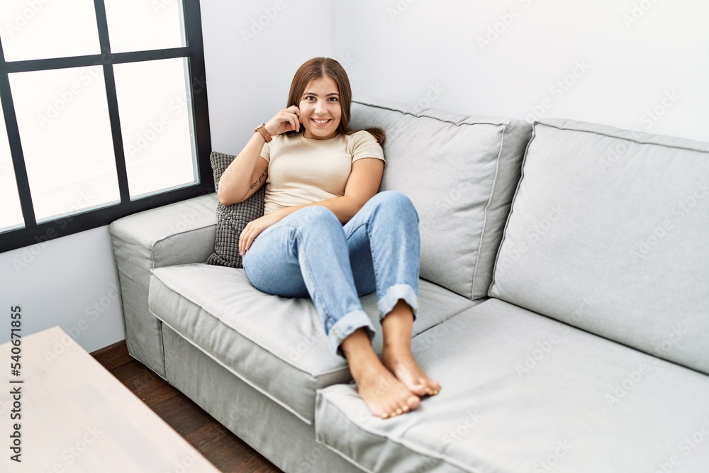 Young hispanic woman smiling confident sitting on the sofa at home Young hispanic woman smiling confident sitting on the sofa at home