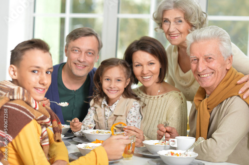 Happy family of different generations eating together 