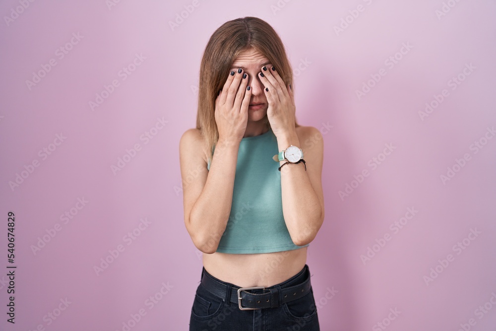 Blonde caucasian woman standing over pink background rubbing eyes for fatigue and headache, sleepy and tired expression. vision problem Blonde caucasian woman standing over pink background rubbing eyes for fatigue and headache, sleepy and tired expression. vision problem