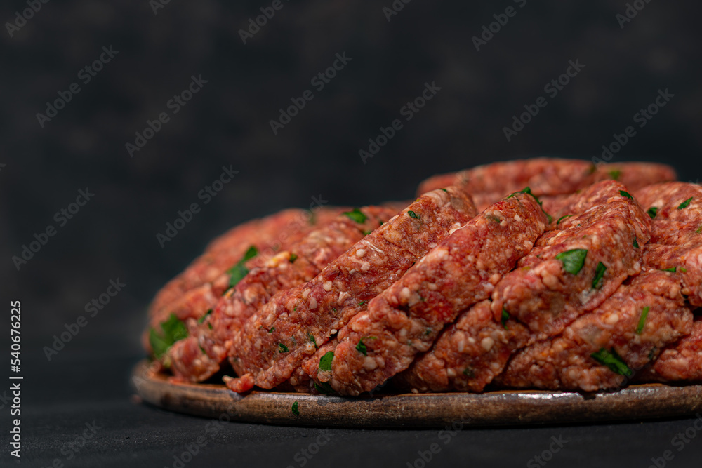 Raw ground meat cutlets on a chopping board. Raw mince on black isolated background. Top view